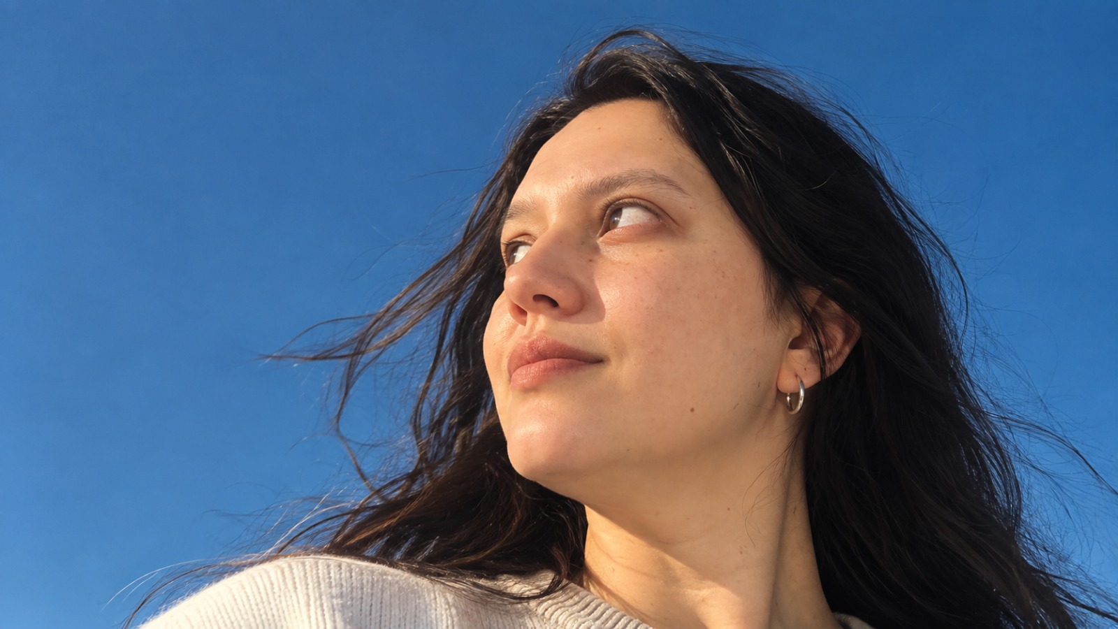 Melischez looking toward the sunlight against a clear blue sky